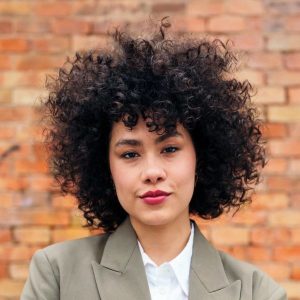 Stock portrait of a woman standing in front of a brick wall